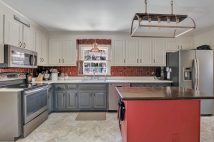 Beautiful kitchen with silestone tops, copper back splash, Slate GE Monogram appliances, and porcelain tile floors.